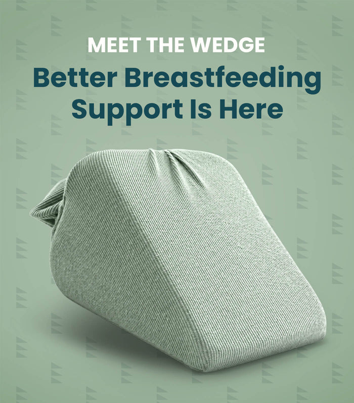 A light sage green wedge breastfeeding support pillow shown on a matching sage green background with promotional text reading 'MEET THE WEDGE Better Breastfeeding Support Is Here'.