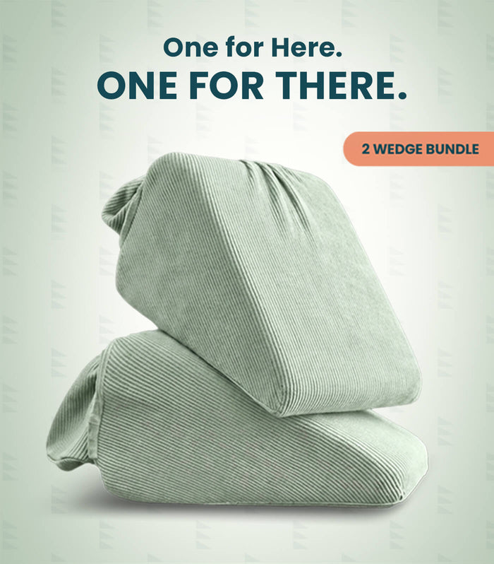 Two pale sage green wedge pillows stacked on a light gray background with promotional text reading 'One for Here. ONE FOR THERE.