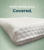 A close-up of a white textured mattress or cushion corner with fringe trim, shown on a pale green background with the text 'EVERY WEDGE SLICE, Covered.'.