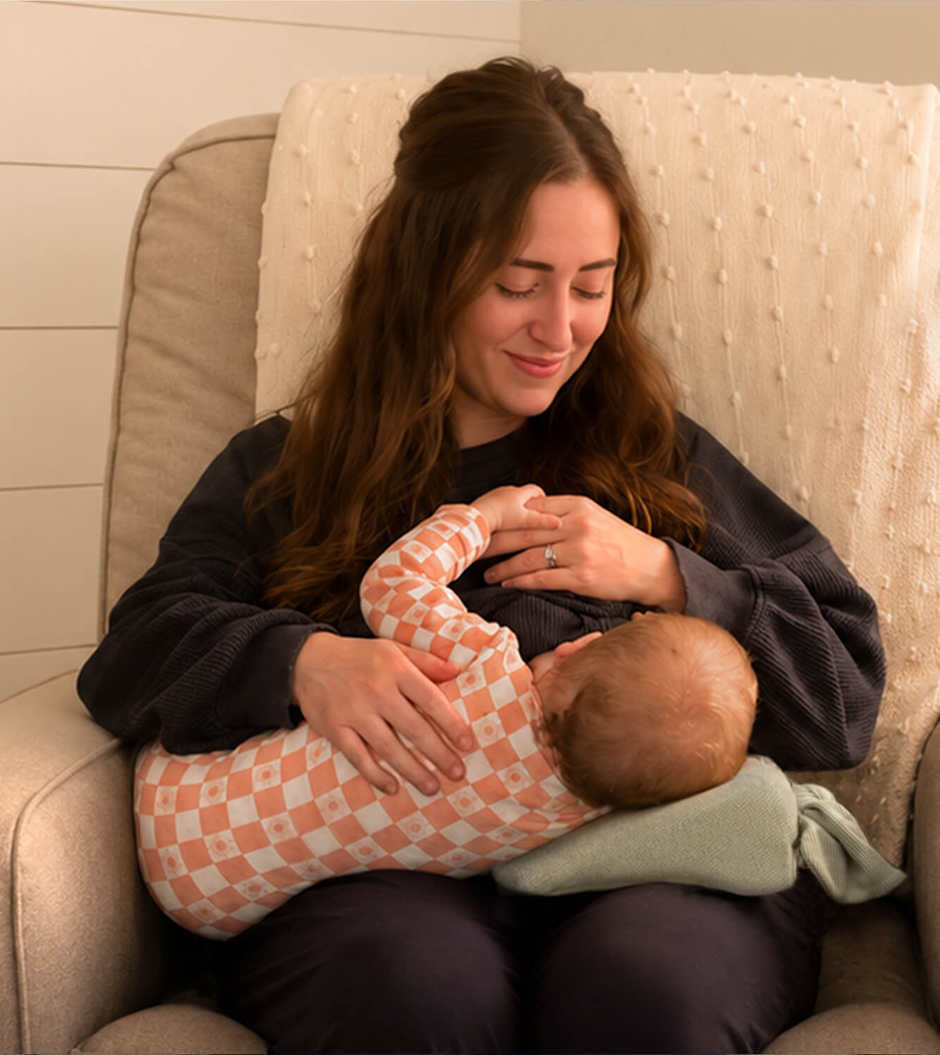 Woman breastfeeding baby using the Acute Baby Co Wedge on its own under the baby's head for added comfort and support. 