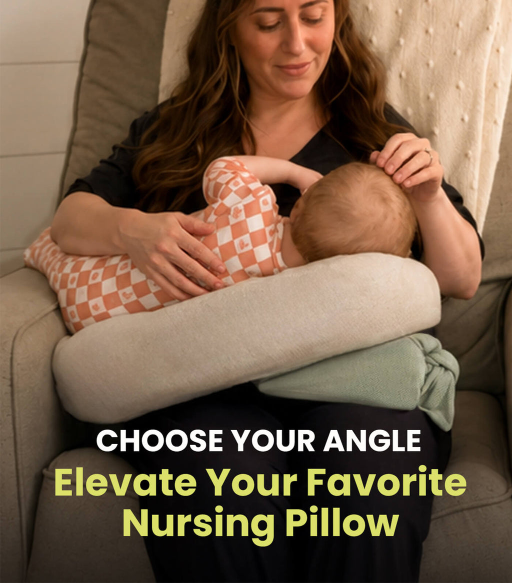 A woman in a gray recliner breastfeeding a baby in a peach and checkered outfit using the acute baby co wedge nursing pillow to elevate another breastfeeding pillow. The image reads 'CHOOSE YOUR ANGLE. Elevate your Favorite Nursing Pillow.'